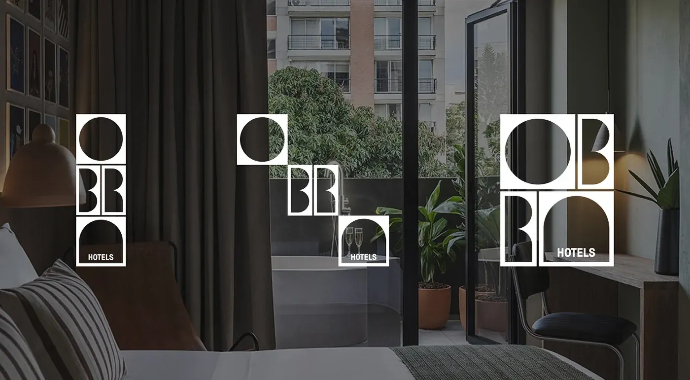 Habitación de OBRA Hotels Medellín con balcón y vista a los árboles y edificios de Astorga.