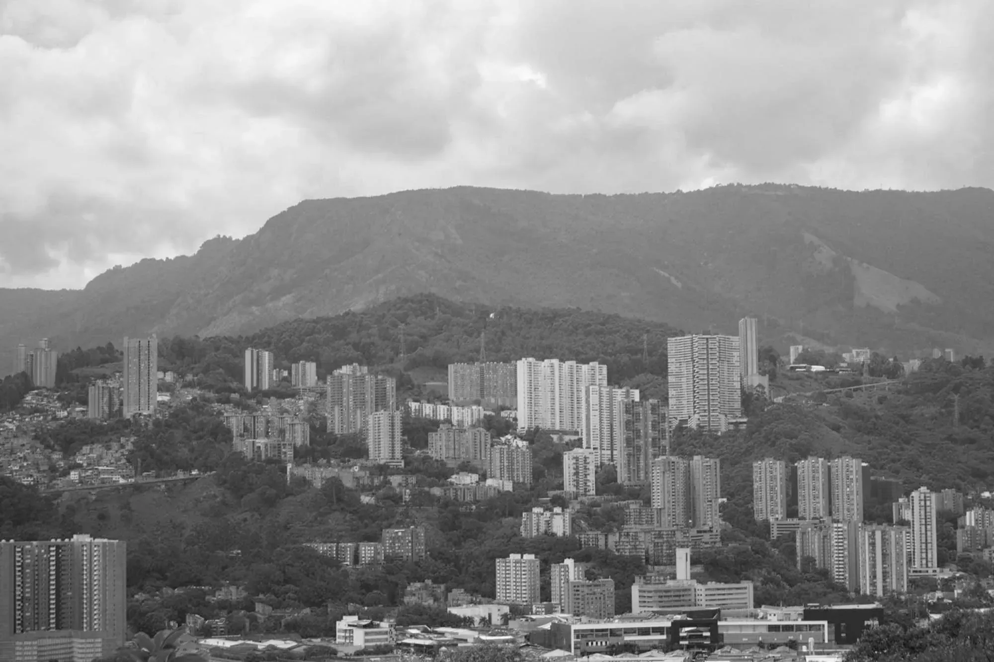 Panorámica en blanco y negro de Medellín con las montañas al fondo.